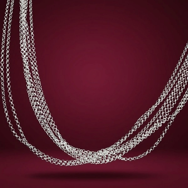 Cadena plata ley 925 estilo rolo con acabado pulido sobre fondo elegante de terciopelo borgoña.